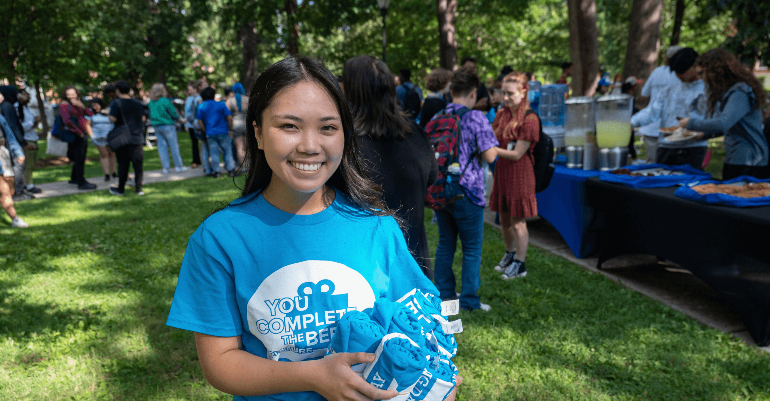 Student Kimberly handing out T-shirts during Berea Patrons outdoor tabling event